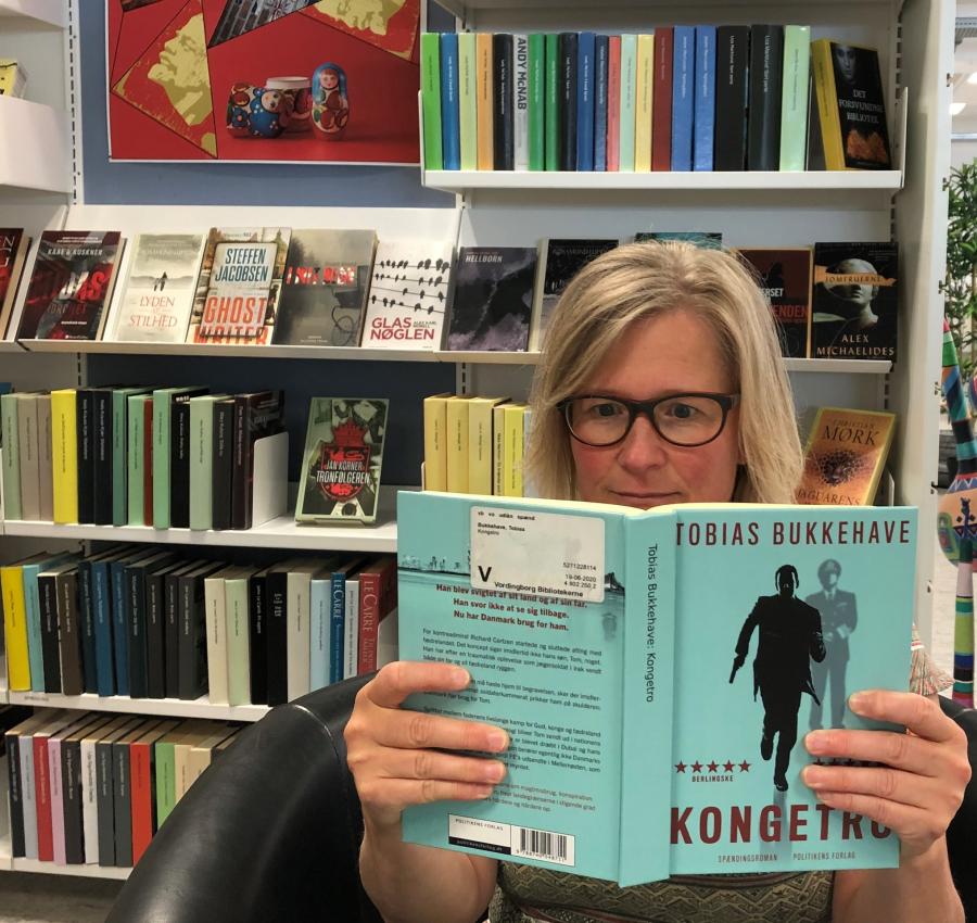 Foto af Birgitte Mølgård Hansen med bogen Kongetro af Tobias Bukkehave